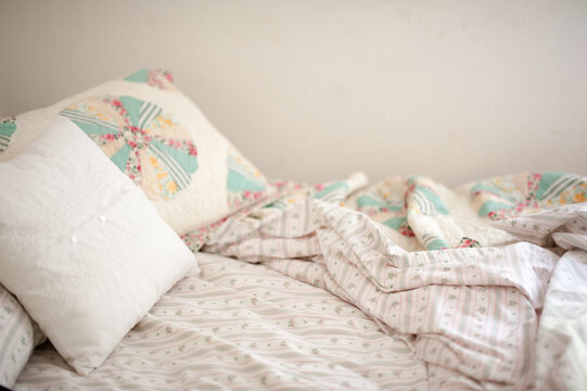 Messy Bed with Vintage Pastel Sheets and Pillows