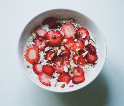 Strawberry breakfast bowl with sliced almonds oatmeal oats and yoghurt