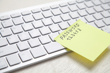 Password message written on sticky note in computer keyboard.