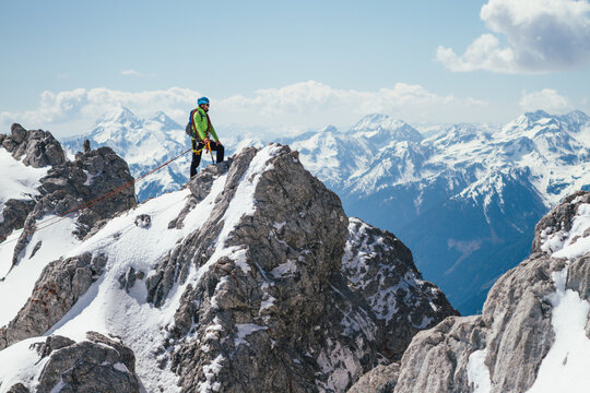 male mountaineer on top of a summit in the austrian alps