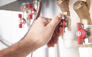 Male hand opens or closes the gas valve.