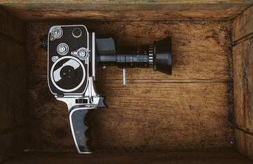 Vintage cinema camera inside an old grungy box.