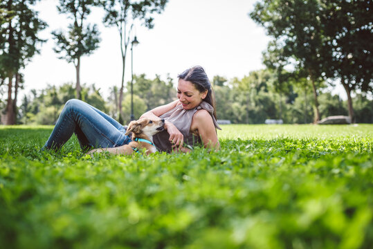 Young woman with puppy sitting in the grass