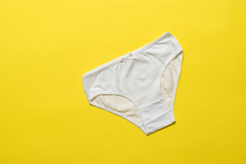 White women's classic style panties on a yellow background. Flat lay.