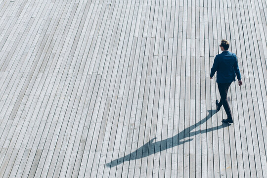 Aerial view of modern businessman walking on a wooden surface