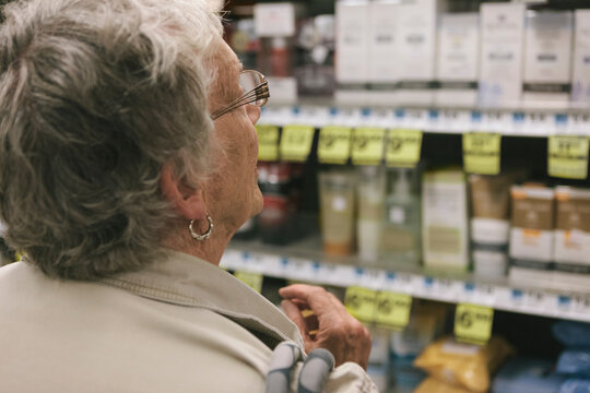 Senior Woman Comparing Products In A Drugstore