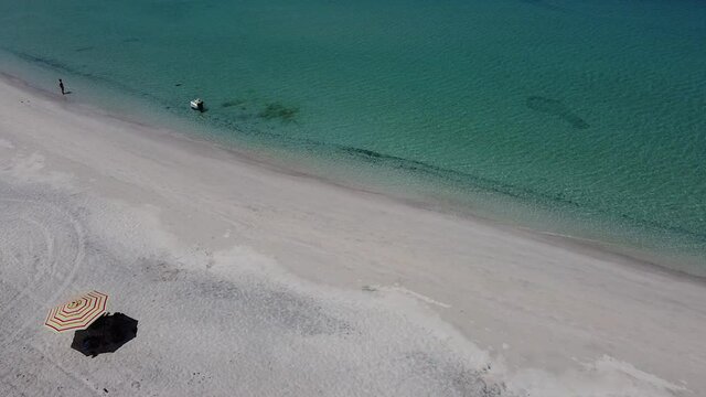 Hombre camina dentro del mar, playa Tecolote, La Paz, Baja California Sur, Mexico.