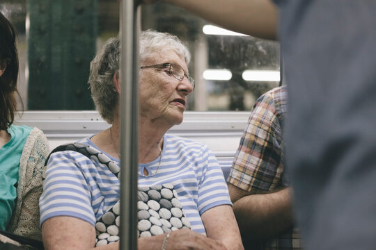 Senior Woman Looking Over Another Passenger's Reading Material