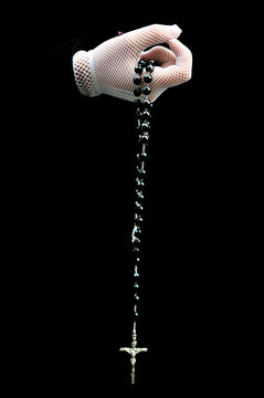 White glove holding a rosary