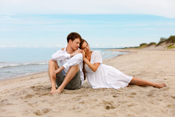 Young couple of lovers enjoy the good weather on the sandy beach