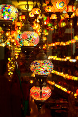 Vertical Image of Arabian Style Multi-color Mosaic Hanging Lamps in a Dark Room