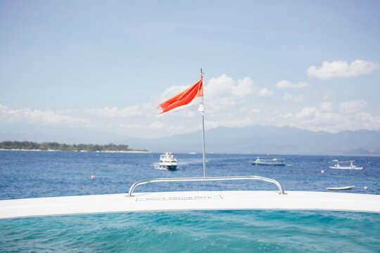The flag of indonesia on the spoiler of a boat.
