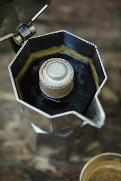 Overhead shot of dark espresso coffee in italian mocha coffee maker pot