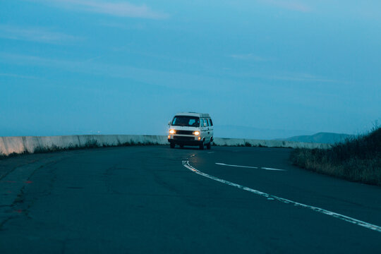 A lonely van drives down a road