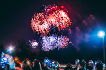 Blurred crowd looking at summer fireworks