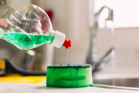 Soap bottle and sponge on the kitchen. Washing dishes.