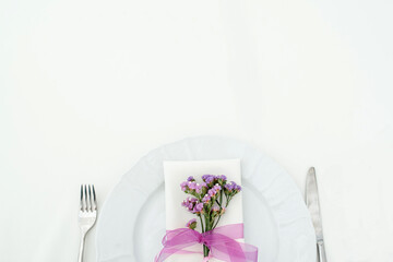 Top view of plate, fork and knife decorated with flowers on party wedding.