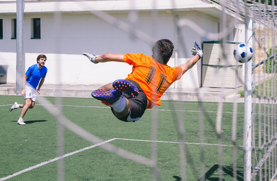 Goal keeper stopping a ball during a football match in a soccer field