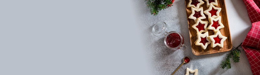 Christmas Bakery banner. Tasty homemade Christmas cookies banner. Traditional Austrian christmas cookies - Linzer biscuits filled with red raspberry jam. Festive decoration. Top view, copy space