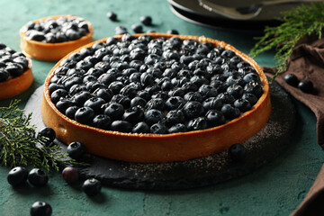 Concept of tasty lunch with blueberry pie on green background