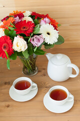 Fototapeta na wymiar teapot, Cup and a beautiful spring bouquet on a wooden table. tea party