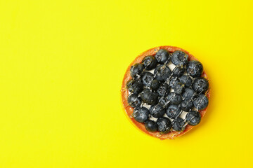 Tasty blueberry pie on yellow background, top view