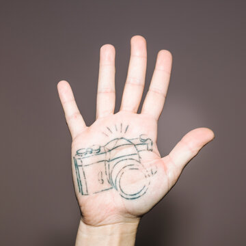 Old camera tattoo on hand