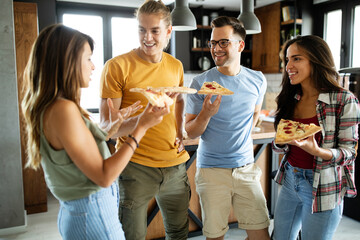 Group of friends are having party at home, eating pizza and having fun.