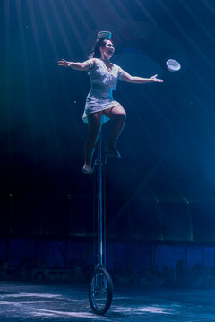 Circus performer on unicycle performing balacing act