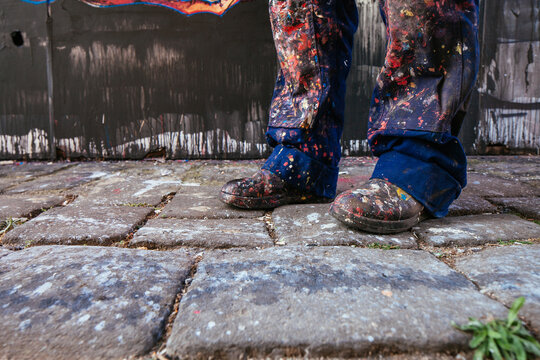Street artist's paint splattered boots