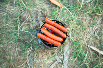 sausages is cooked on the camping wood stove