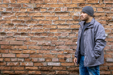 Man on the background of a red brick wall.