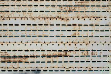The wall is made of old rusty metal.