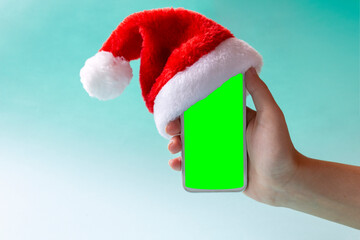Phone with santa hat on and copy space on chroma key.  Digital New year and christmas concept