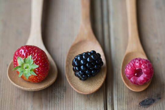 Fresh berries arranged on wooden spoons
