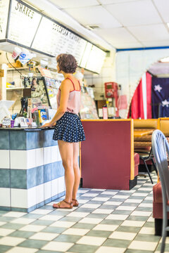 Woman Waits to Order at the Counter of a Ice Cream Parlor