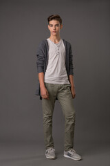 Obraz premium Handsome teen guy in grey cardigan and white tank top