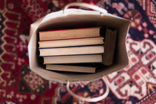 A selection of vintage books in a paper bag