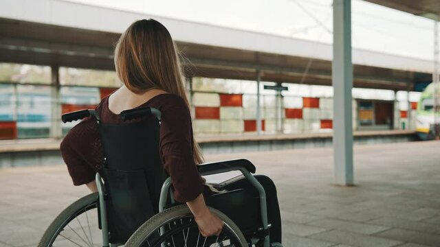 Happy young independent disabled woman on the train station. High quality 4k footage