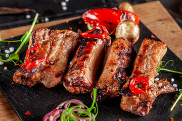 American cuisine. Fried pork ribs in josper. Serving food in a restaurant on a wooden board.
