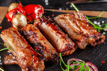 American cuisine. Fried pork ribs in josper. Serving food in a restaurant on a wooden board.