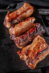 American cuisine. Fried pork ribs in josper. Serving food in a restaurant on a wooden board.