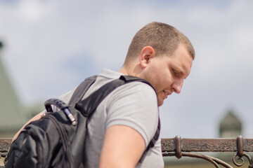 A man with a backpack climbs up, he travels around the city