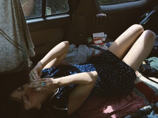 Woman Playing Harmonica in Back of Car