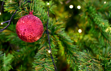 Closeup of Christmas Ball on Christmas Tree with bokeh beautiful background for design and decoration, new year concept, selective focus.