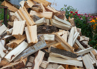 A pile of split wood in the yard.Preparation for winter.Firewood for heating the house during the cold period.
