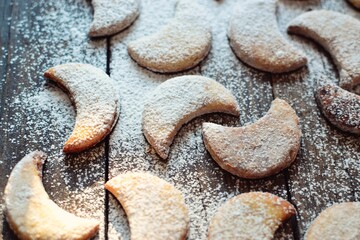 Shortbread New Year's, Christmas cookies in the shape of the moon. A child sprinkles cookies with powdered sugar. Baby and cookies. Child's hands in icing sugar and flour. The girl is cooking.