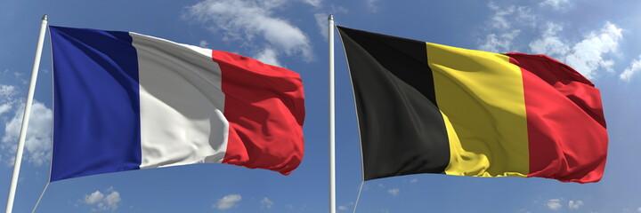 Flying flags of France and Belgium on high flagpoles. 3d rendering