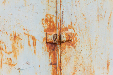 Rust.Old rusty metal door with holes for a padlock.