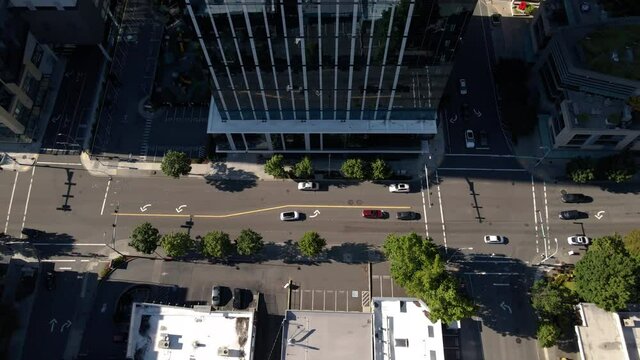 Birds Eye View of Cars Driving City Street Panning Up to Buildings in Cityscape